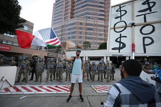 A man holds a US/Mexican flag during anti-ICE protests in Los Angeles on Thursday
